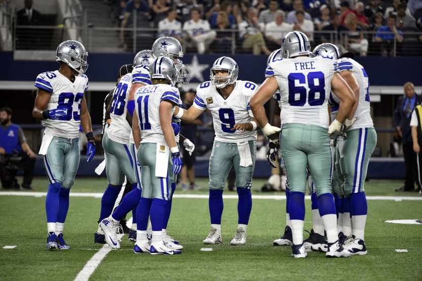 Dallas Cowboys quarterback Tony Romo (9) directs the offense in the huddle as they played an...