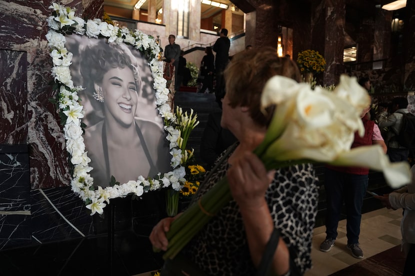 Un asistente mira un retrato enmarcado con flores de la actriz mexicana Silvia Pinal,...