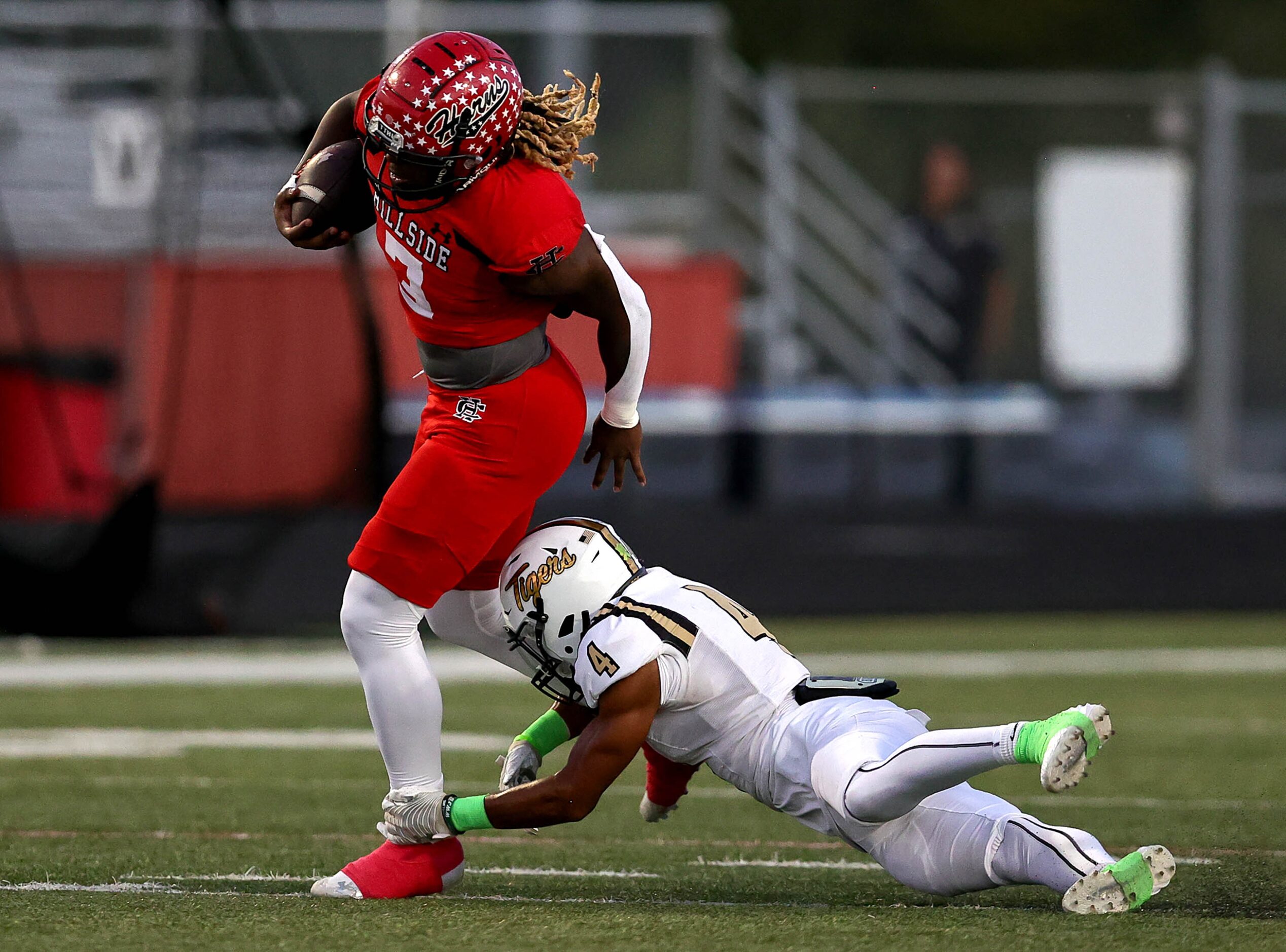 Cedar Hill running back Zhaiylen Scott (3) tries to slip past Mansfield safety Dylan Thrash...