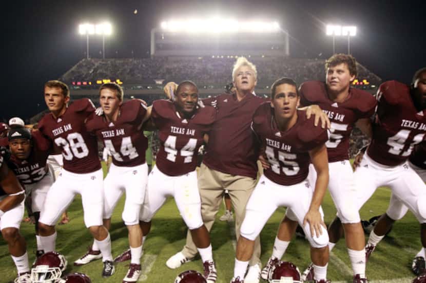 Texas A&M football coach Mike Sherman locked arms and swayed with his players during the...
