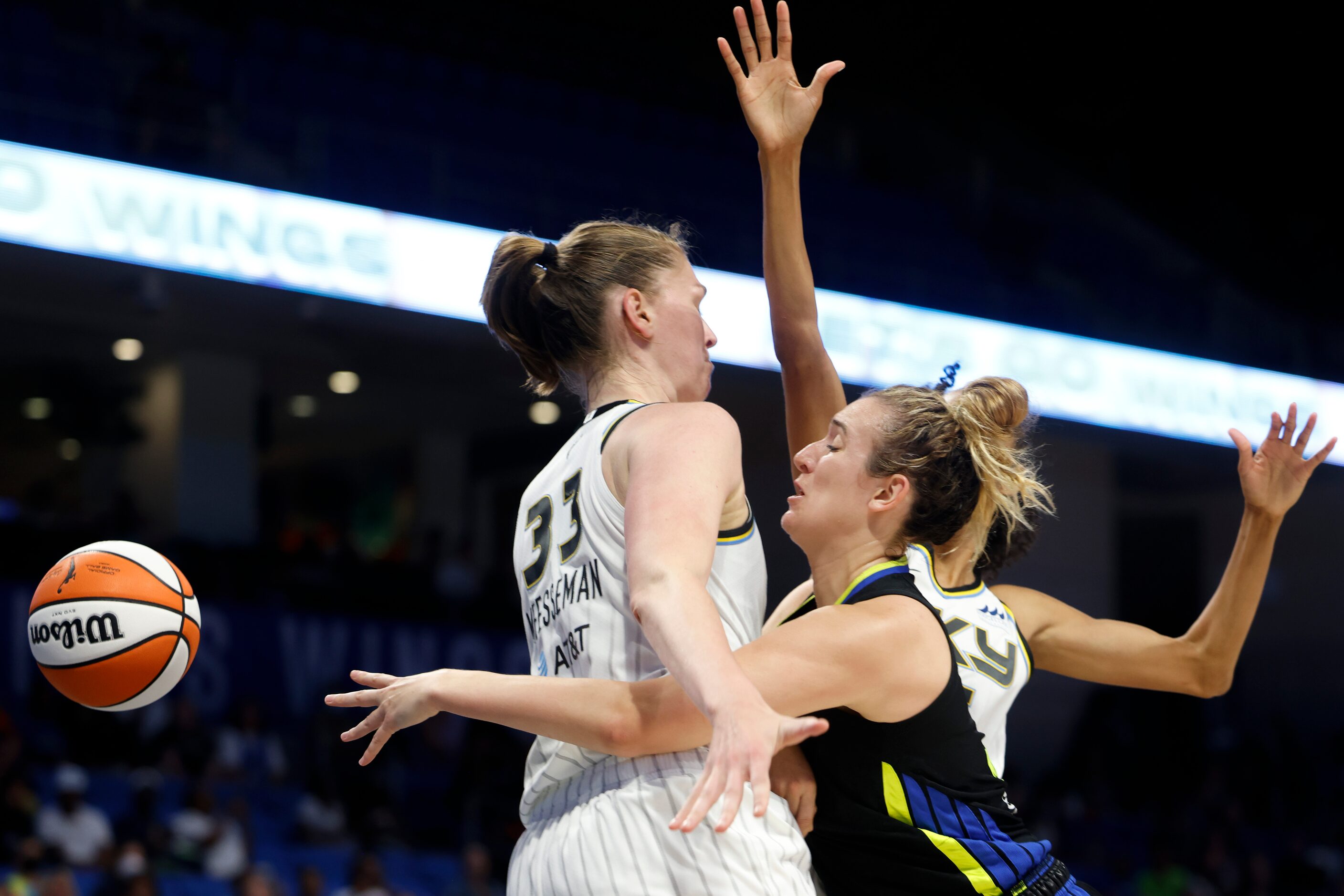 Dallas Wings guard Marina Mabrey, center, passes past Chicago Sky forward Emma Meesseman,...