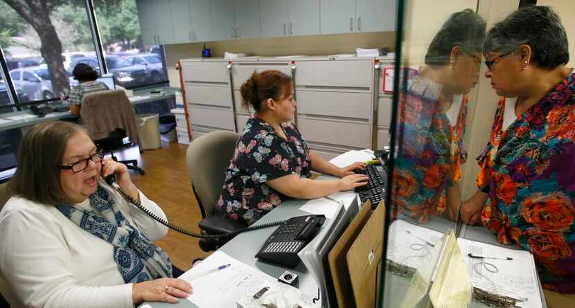 
Dolores Maria Laviada (right) checks for an appointment for her mother with the staff...