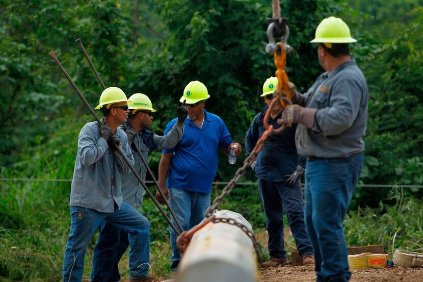 A Puerto Rico Electric and Power Authority brigade work in a remote off-road location to...