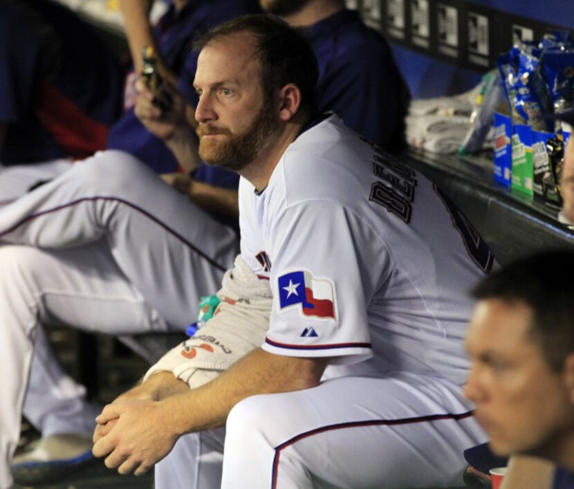 Texas Rangers starting pitcher Ryan Dempster (46) watches from the dugout with his arm...