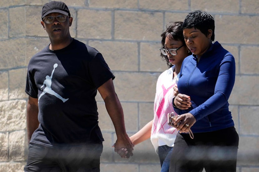 Parents walk their child out of Apalachee High School after a shooting at the school,...