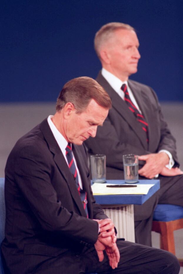 President George H.W. Bush looks at his watch during a presidential debate at the University...