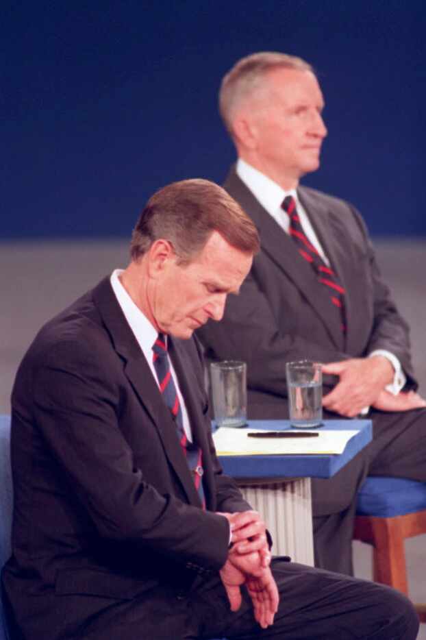 President George H.W. Bush looks at his watch during a presidential debate at the University...
