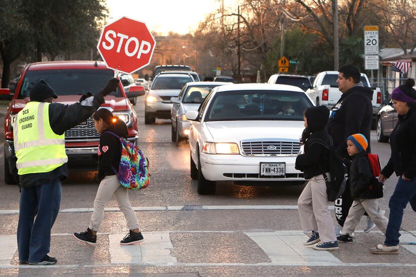 Russell Roberson, 77, helps students and parents cross the street at Lorenzo De Zavala...
