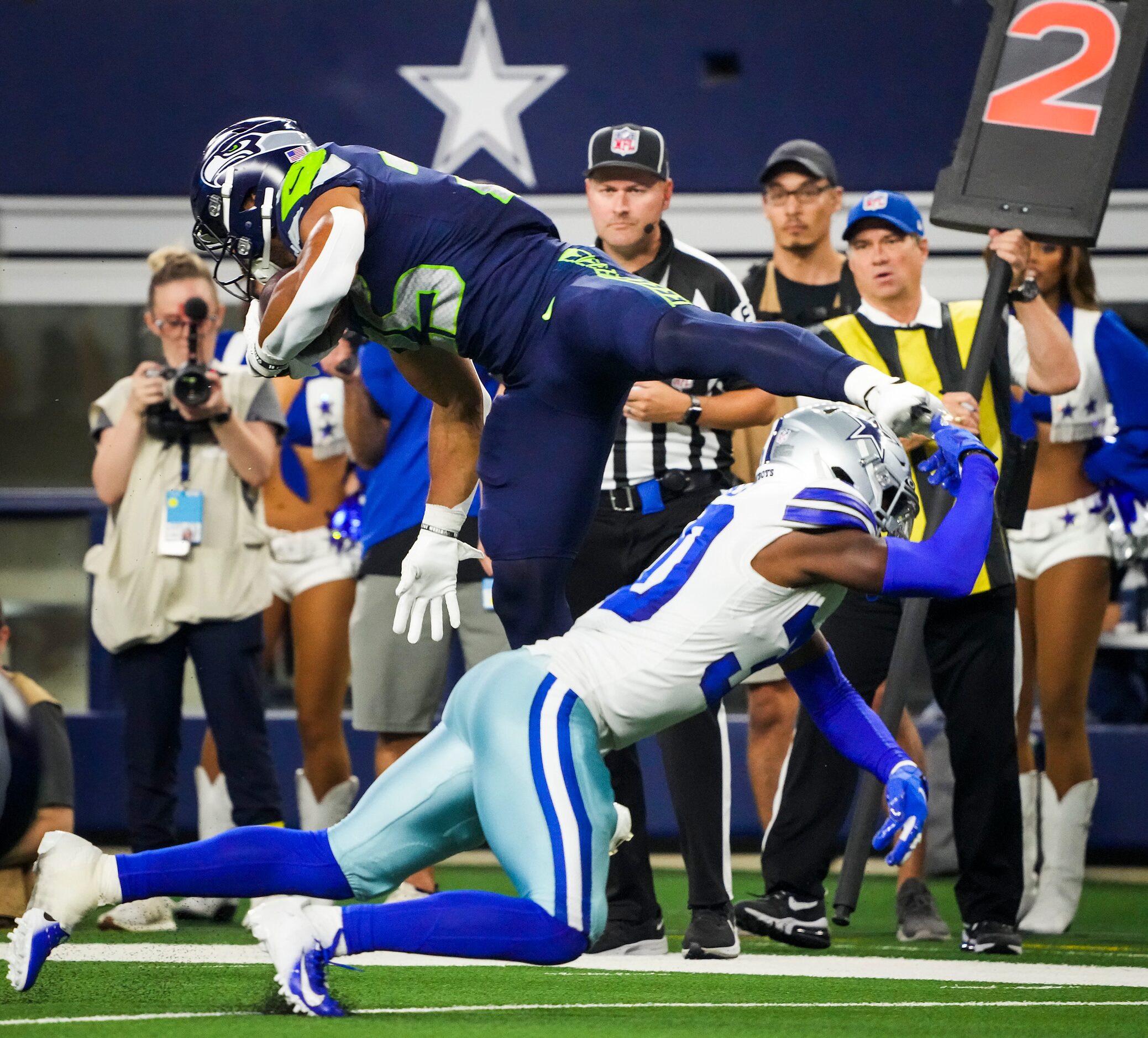 Seattle Seahawks running back Travis Homer (25) is tripped up by Dallas Cowboys cornerback...