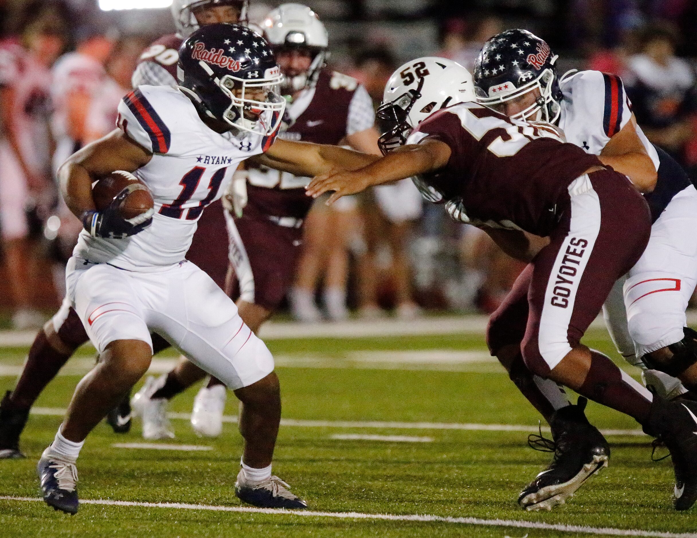 Denton Ryan High School running back Michael Davis (11) is stopped by Frisco Heritage High...