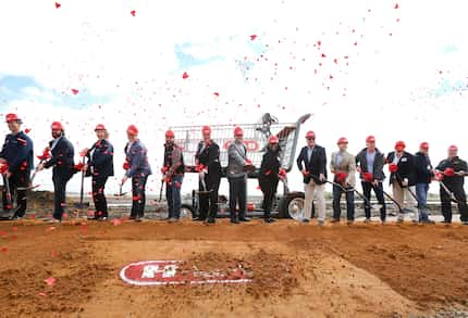 Proper city officials and H-E-B executives performed the ceremonious pitching of the dirt at...