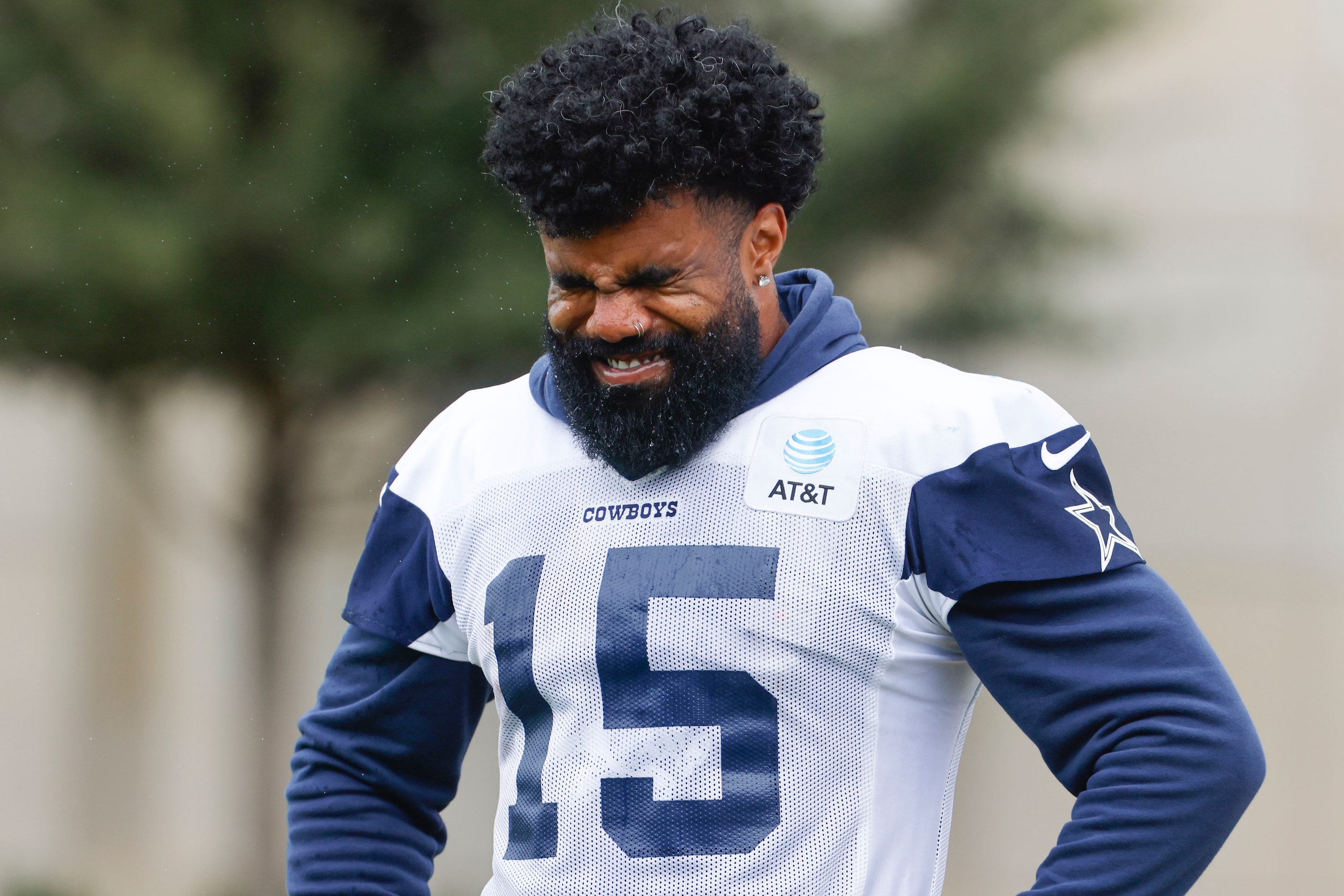 Dallas Cowboys running back Ezekiel Elliott (15) reacts as he pauses between drills during a...