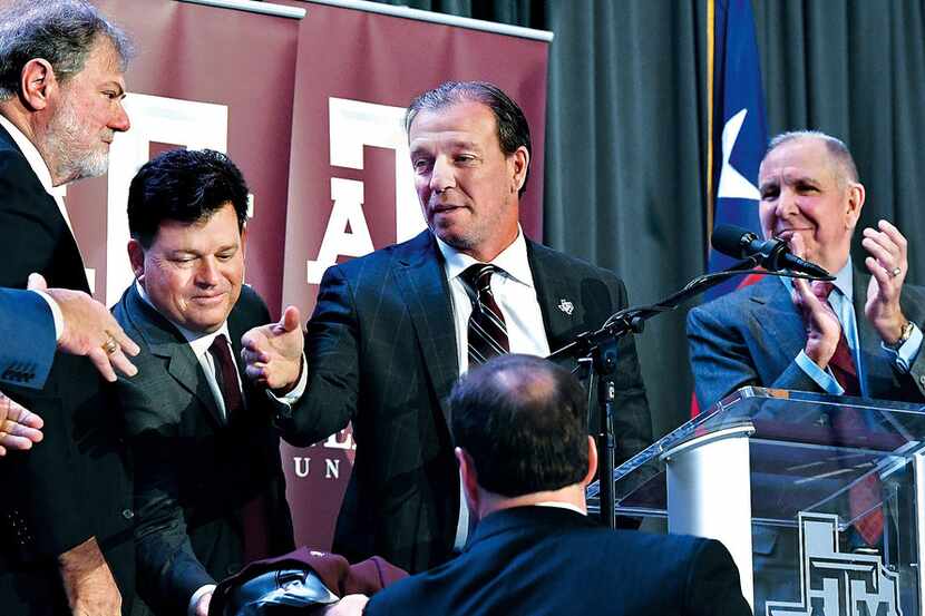 Jimbo Fisher, second from right,  reaches out to shake the hand of A&M Chancellor John...