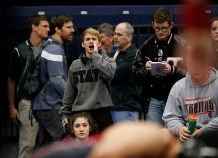 Euless Trinity's Mack Beggs (center left) cheers on his teammates during the Class 6A Region...