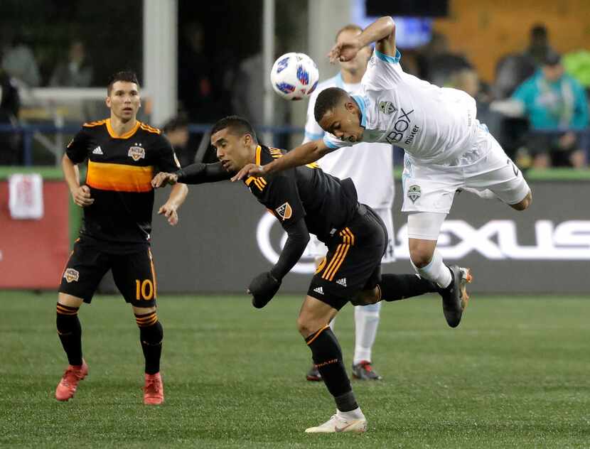 Seattle Sounders midfielder Jordy Delem, right, leaps above Houston Dynamo forward Mauro...