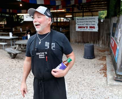 Owner Kerry Bexley prepares to give away a koozie and a bottle of barbecue sauce to a random...