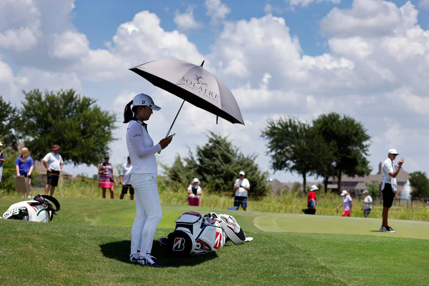 Professional golfer Jin Young Ko shields herself from the sun after making birdie on No. 8...