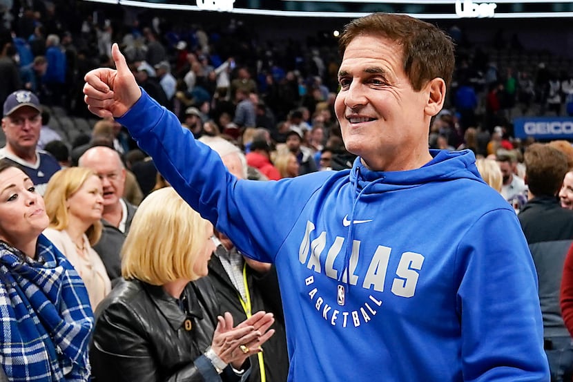 Dallas Mavericks owner Mark Cuban gives a thumbs up to the crowd as he leaves the court...