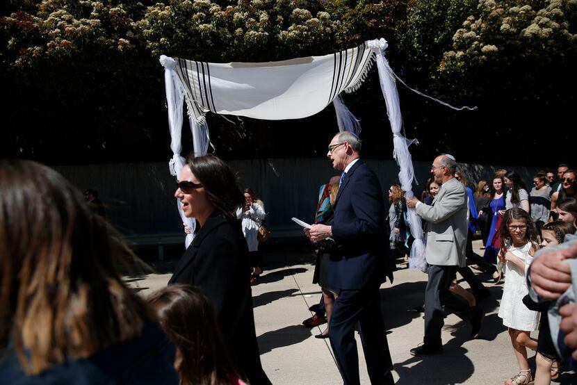 Rabbi Stefan Weinberg sings during a procession carrying a torah made in honor of his late...