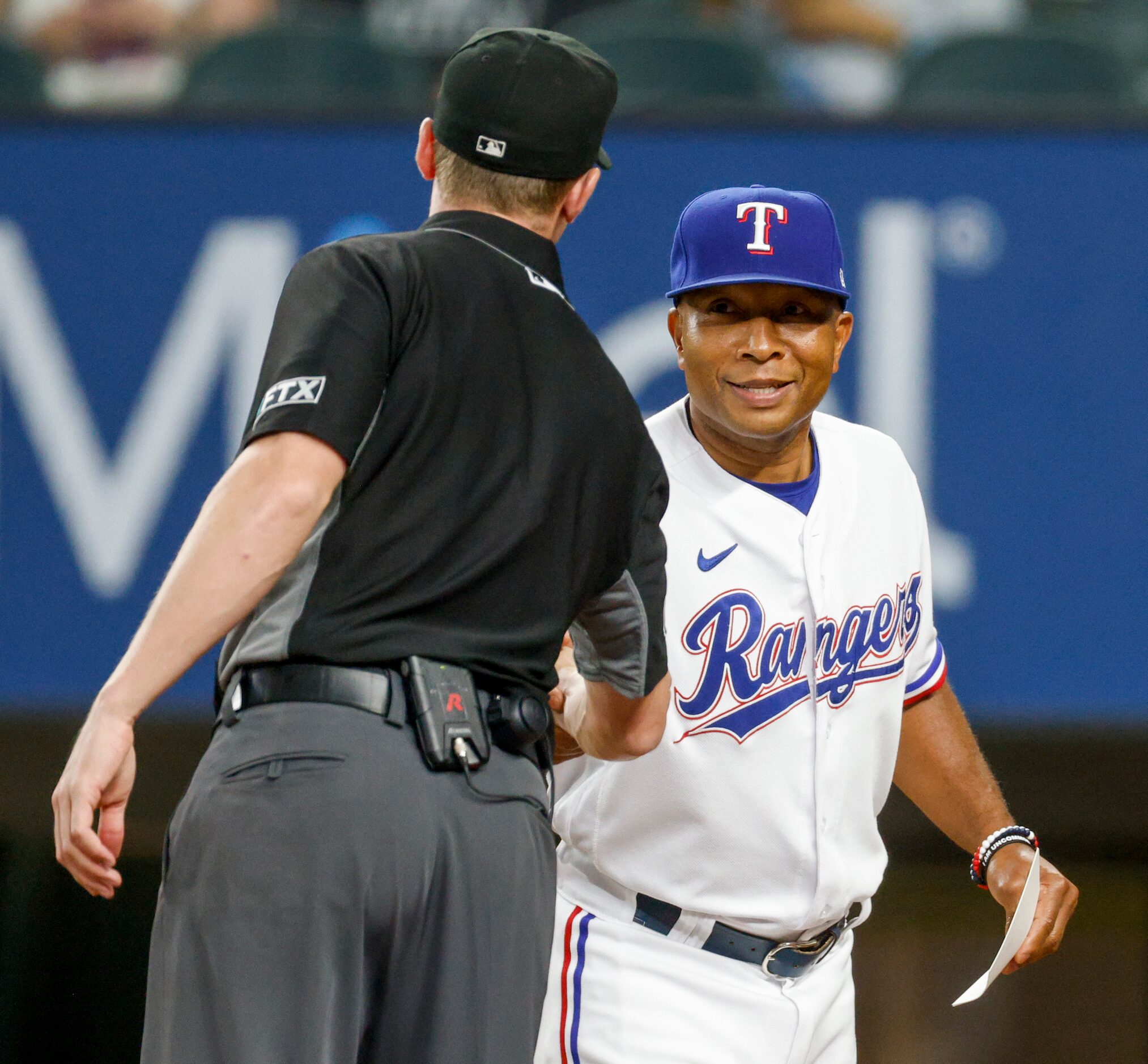 Texas Rangers interim manager Tony Beasley (27) shakes hands with an umpire before a game...