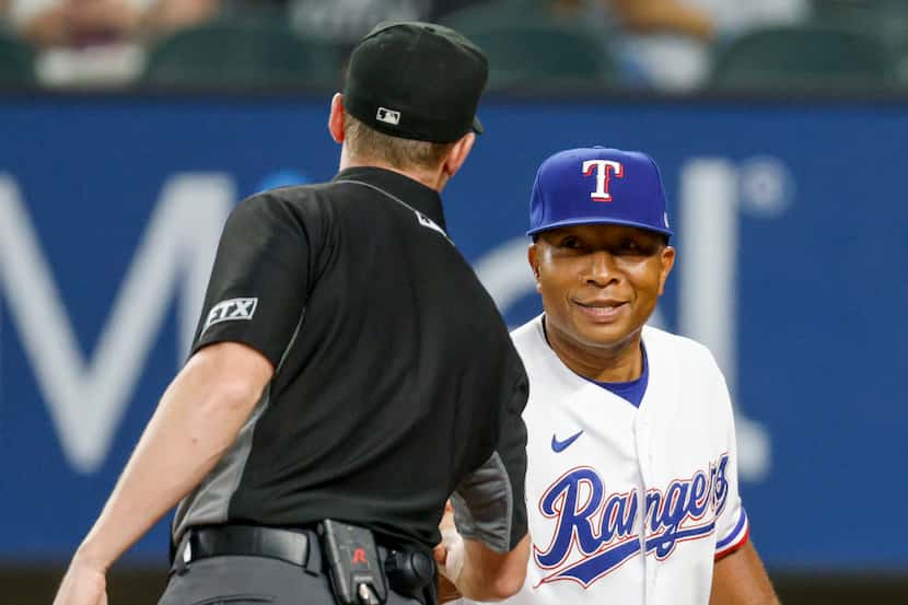 Texas Rangers interim manager Tony Beasley (27) shakes hands with an umpire before a game...