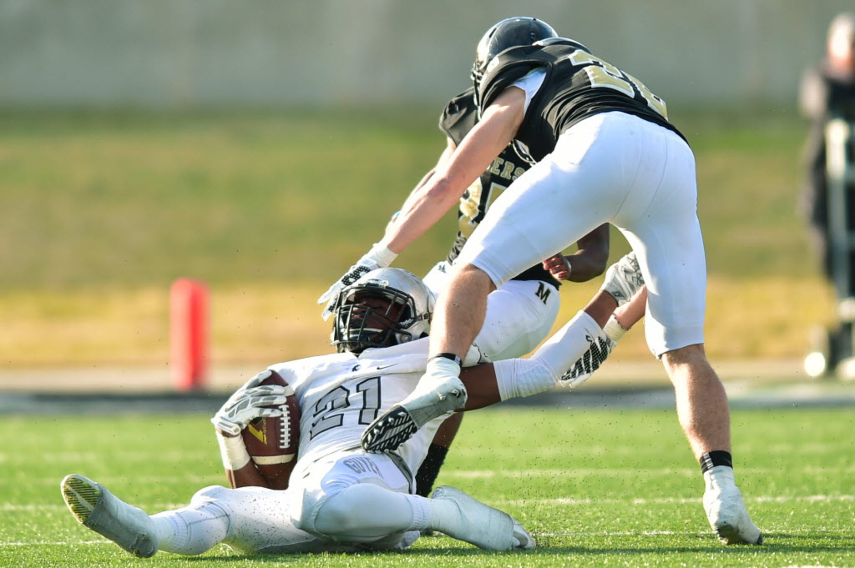 Guyer junior running back Christian Moore (21) is slammed by Mansfield senior linebacker...