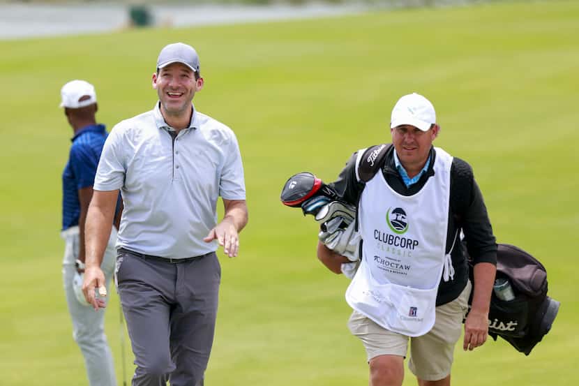 Former Dallas Cowboys quarterback Tony Romo laughs while walking with his caddie Chris Brown...