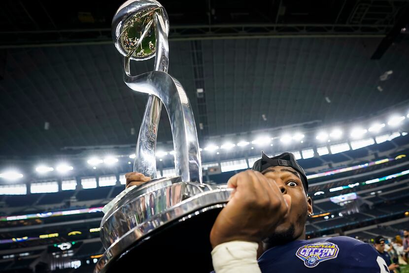 Penn State linebacker Cam Brown lifts the championship trophy after the Nittany Lions 53-39...