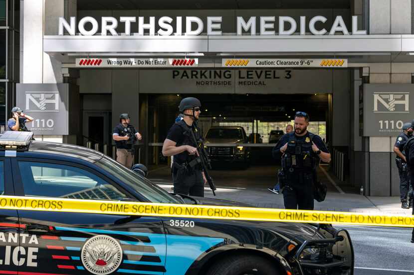 Law enforcement officers stand Northside Hospital Midtown medical office building, where...