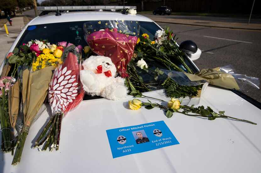 Flowers covered the windshield of a Dallas police car as people paid their respects to...