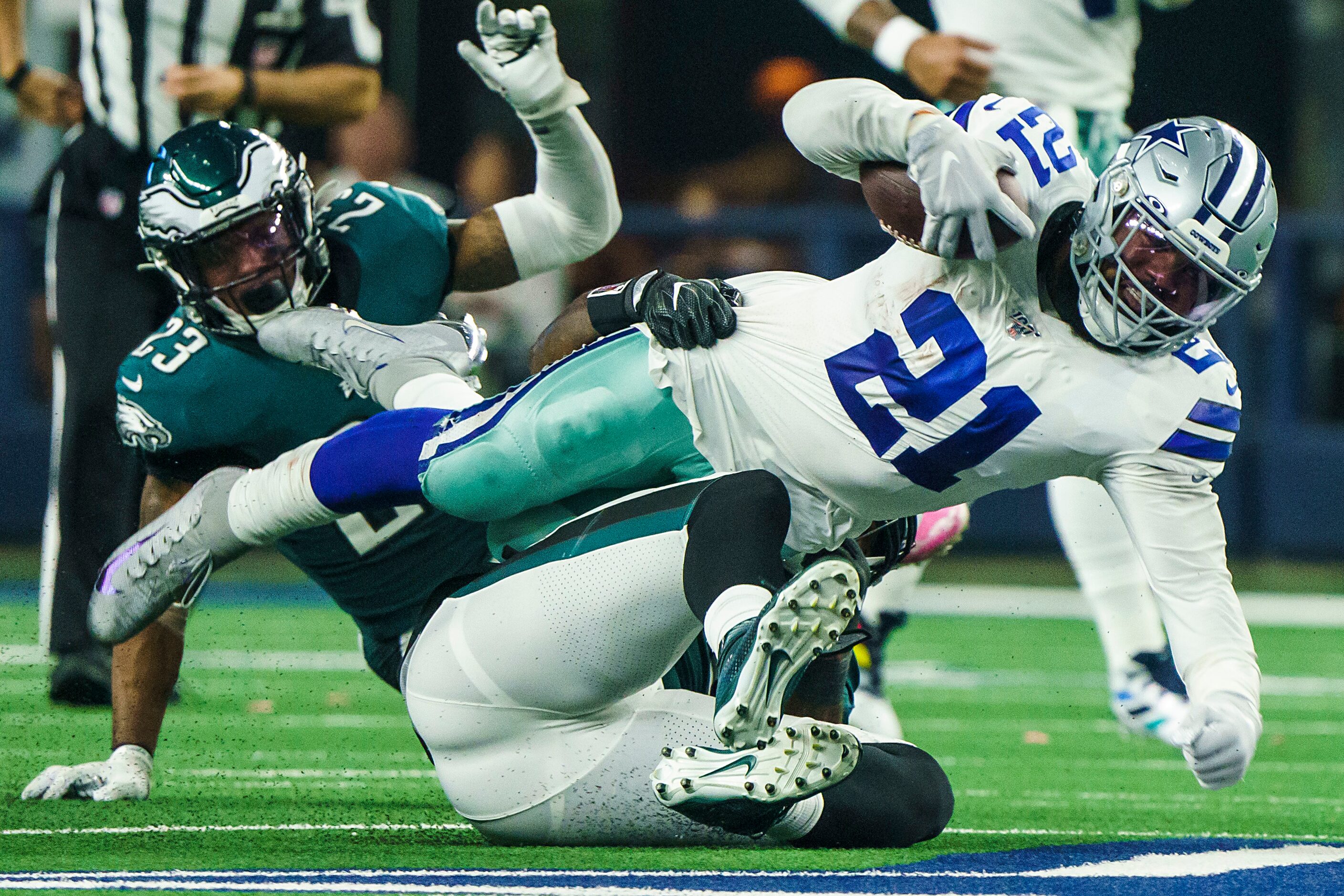 Dallas Cowboys running back Ezekiel Elliott (21) is knocked off his feet by the Philadelphia...