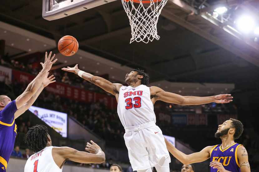 SMU guard Jimmy Whitt Jr. (33) reaches for a rebound over East Carolina forward Dimitrije...