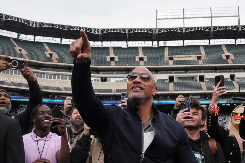 Dwayne “The Rock” Johnson points to the crowd before the XFL football game between the...