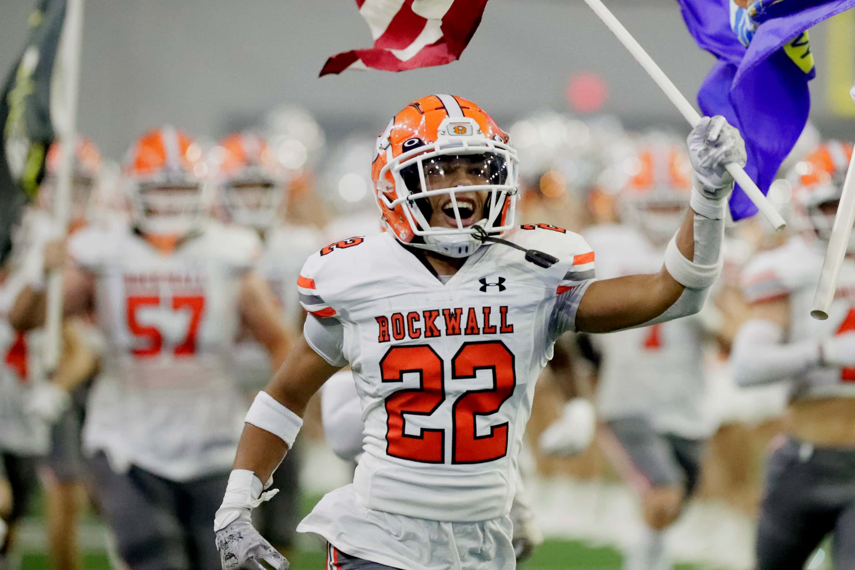 Rockwall High School running back Parker Williams (22) carries a flag as his team takes the...