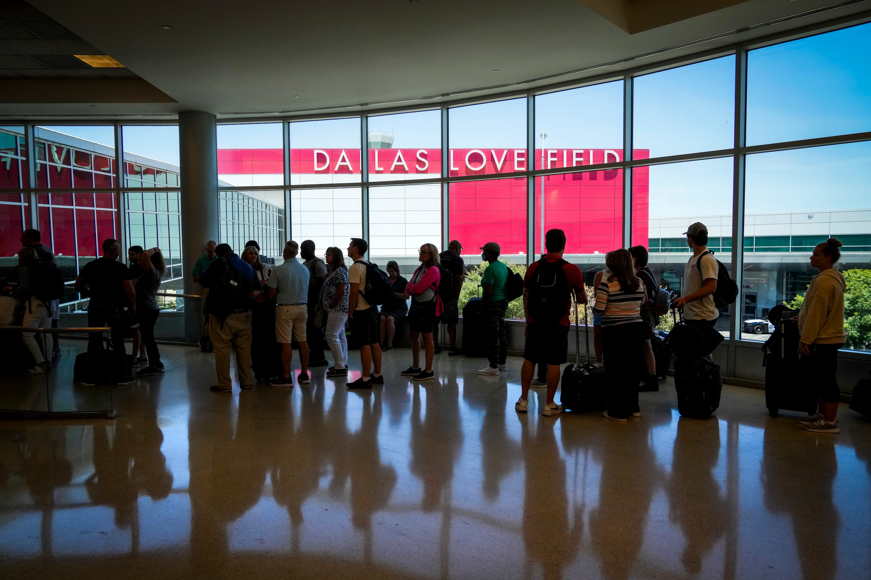 Passengers wait to reenter Dallas Love Field Airport on Monday, July 25, 2022.  A ground...