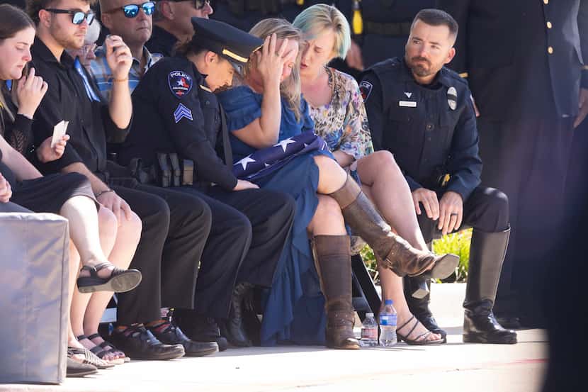 Lynette McMichael (center) is comforted during her husband’s, funeral at Crossroads...
