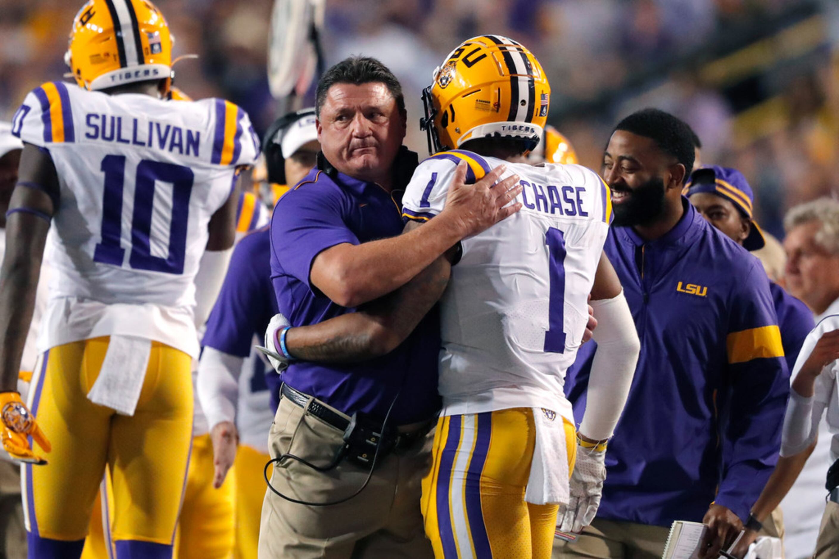 LSU coach Ed Orgeron hugs wide receiver Ja'Marr Chase (1) on the sideline after his...