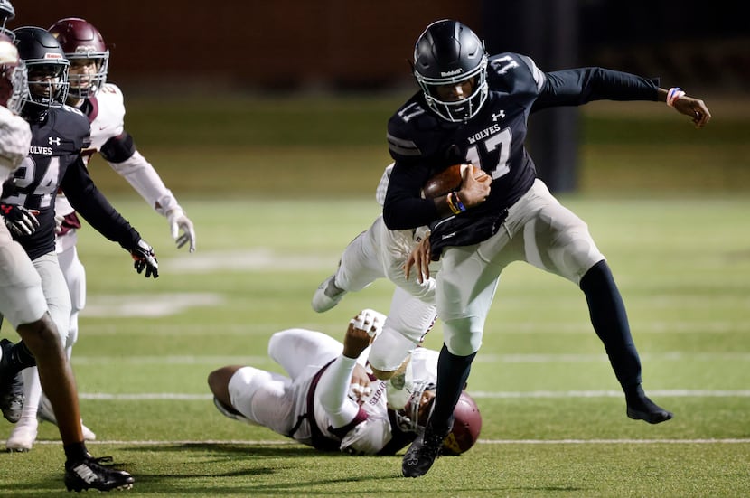 Mansfield Timberview quarterback Zuric Humes (17) sheds a pair of Frisco Heritage tacklers...