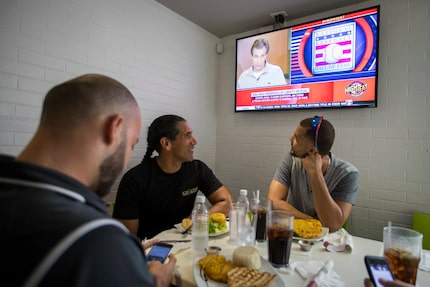 Alex Claudio (right) and his trainer Luis Cadiz look up as news of this year's National...