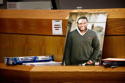 A photo of Botham Jean leans against Judge Tammy Kemp's bench. 