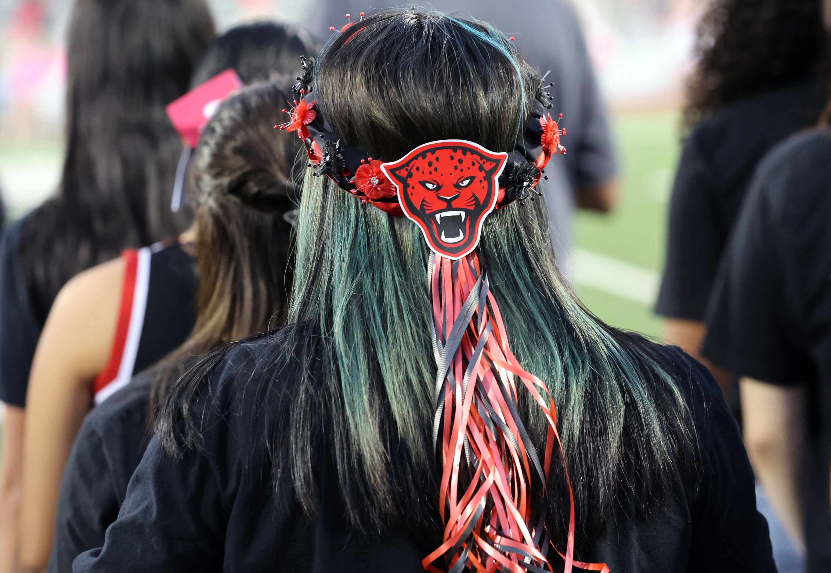 A student Mesquite Horn high student fan displays school spirit by wearing a Jaguar headband...