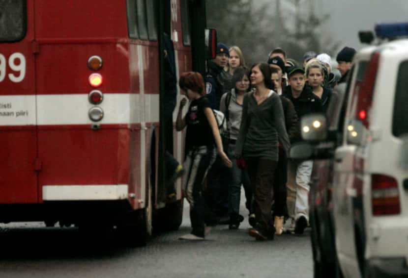 Students board a bus after being evacuated from the Jokela High School on Nov. 7, 2007, in...
