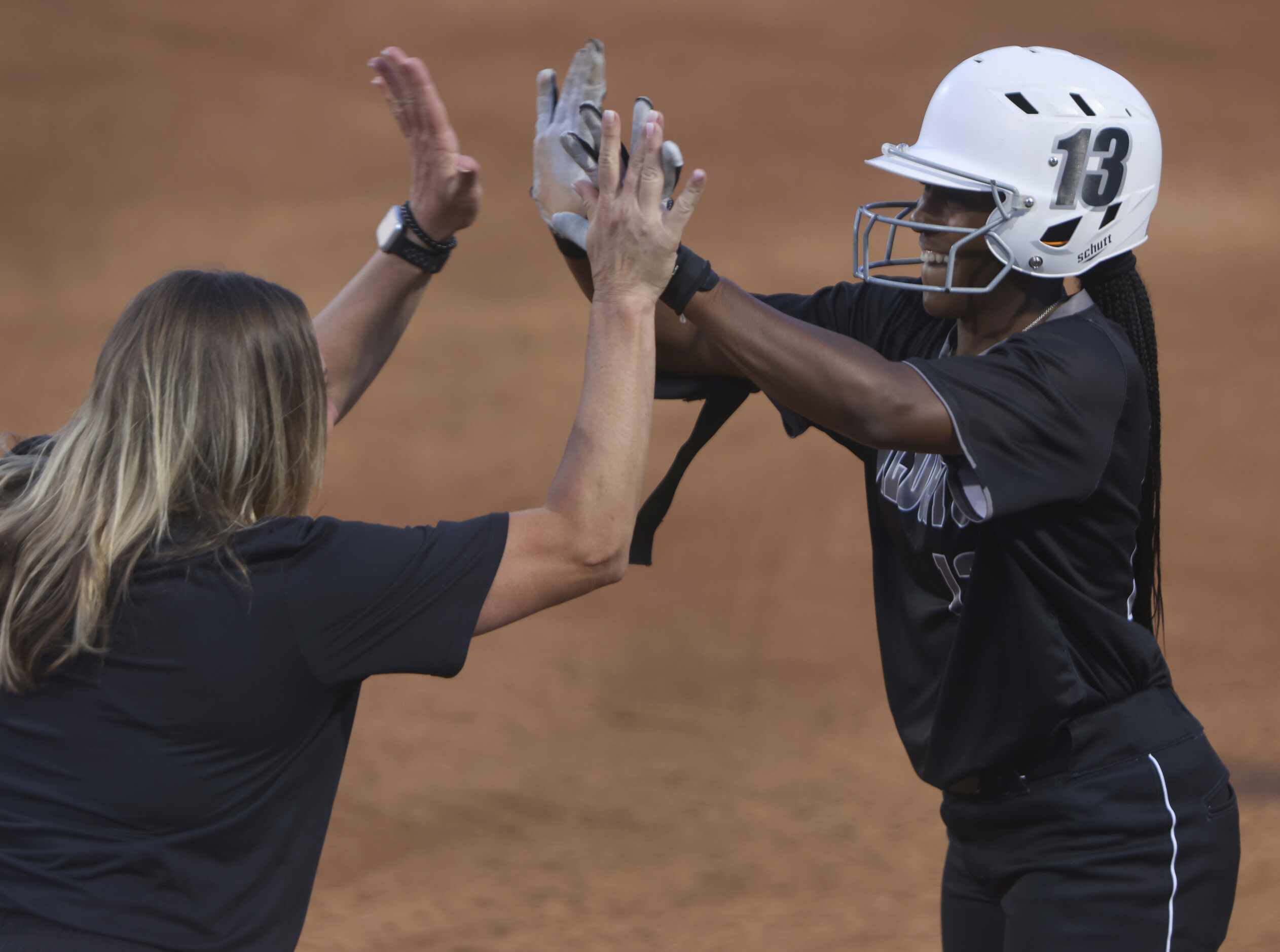 Denton Guyer outfielder Briana Williams (13), high fives an assistant coach after beating...