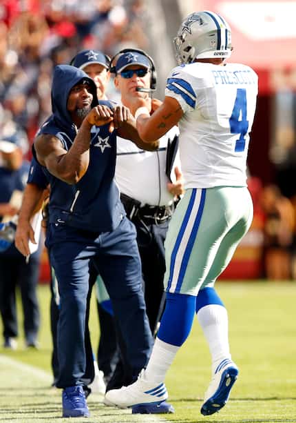 Dallas Cowboys quarterback Dak Prescott (4) receives a double fist bump from injured wide...