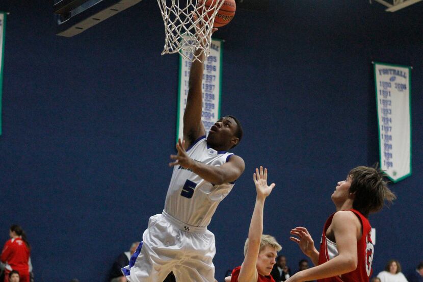 Prince Giadolor finishes a drive with a layup for the Lakehill varsity boys basketball team...