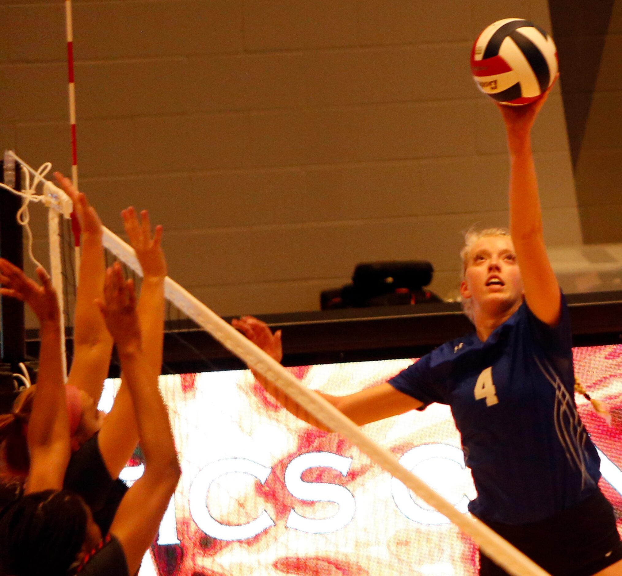 Denton Guyer's Brooke Slusser (4) lofts a soft return against a defensive front by Arlington...