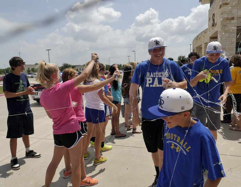 Sunnyvale High School cheerleaders spray Wesley Phillips, center, Tye Arden, son of head...