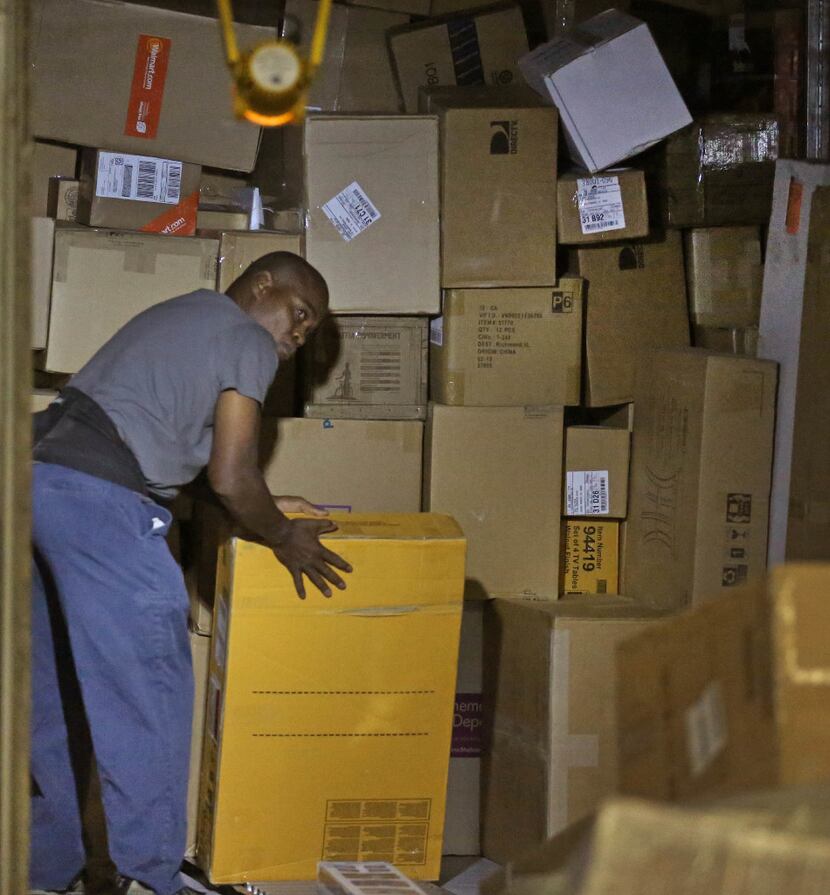 FedEx Ground employees unloaded packages at the Dallas Hub in Hutchins on Thursday. (Louis...