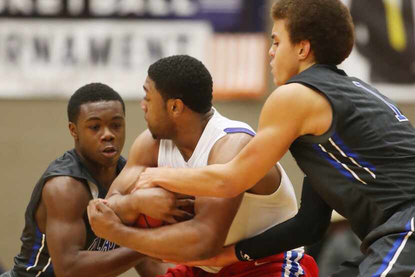 Plano West's Derrick Aimes, 11, and DJ Hogg, 1, tie up Little Rock Parkview's Ryan Pippins, ...