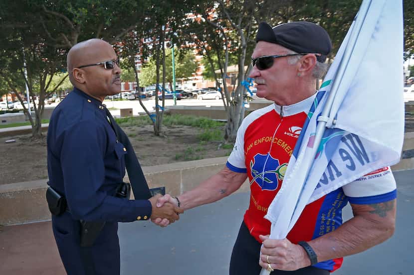 John Lawton (left), an assistant chief who's now a major, shook hands with a retired police...